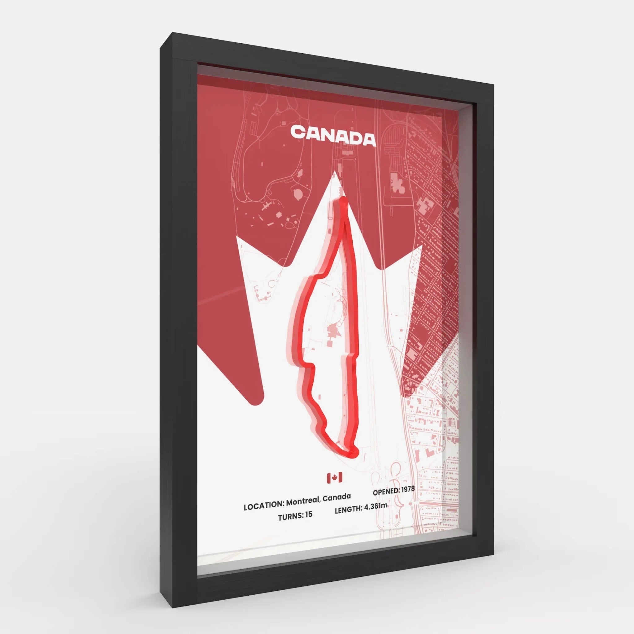 A framed Canada racing map print with a black frame, featuring a red maple leaf outline and track graphic on a white background with faint map details.