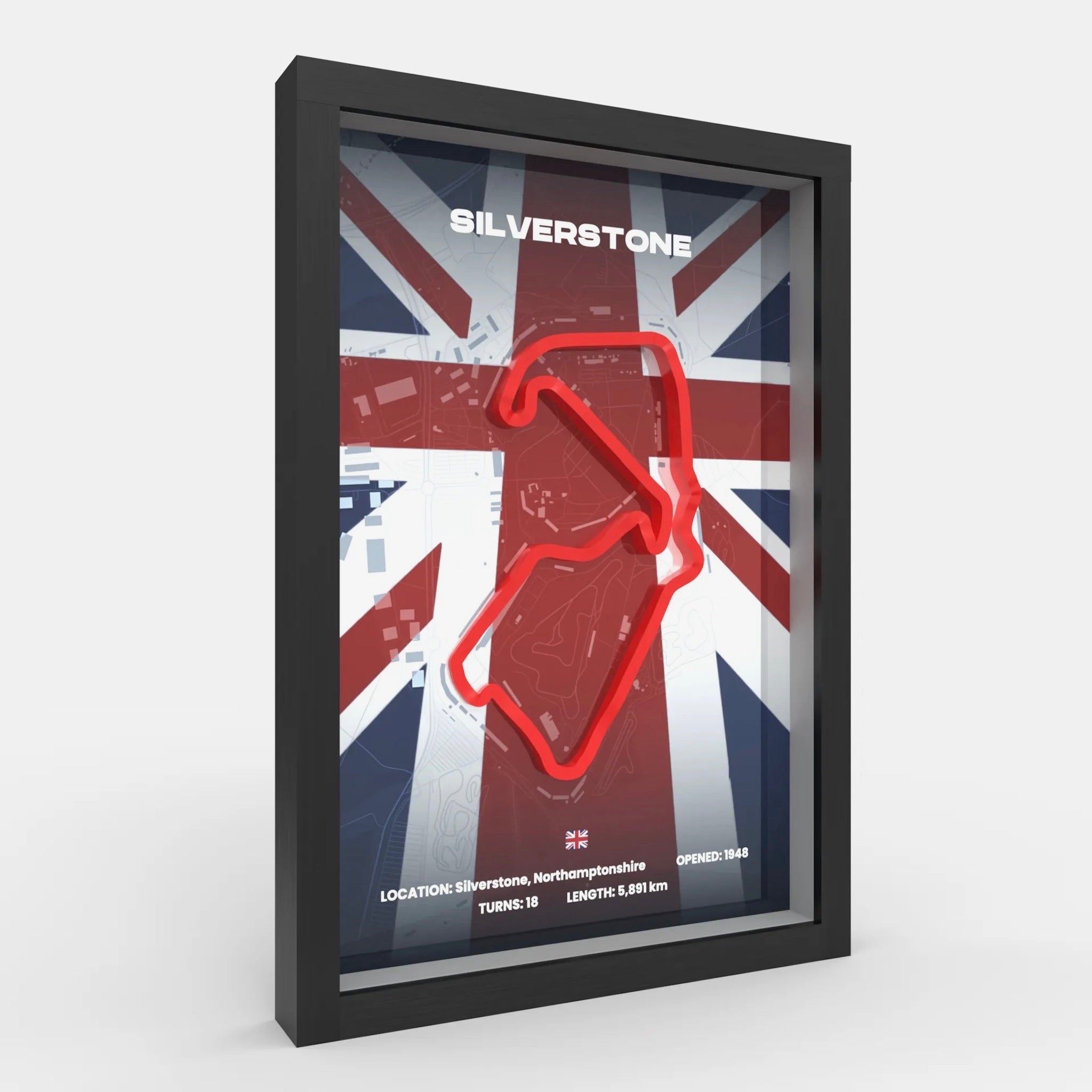 A framed racing poster featuring a red neon-style Silverstone track outline over a Union Jack background, shown in a black frame on a light gray studio background.
Silverstone Formula 1 track framed wall art front display