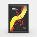 A framed poster featuring the Spa-Francorchamps race track layout in Belgium, with a black background, bold yellow and red graphic elements, and white text including 'SPA FRANCORCHAMPS'. The poster is shown inside a black frame against a light gray studio background.
Spa Francorchamps F1 track framed wall art front view