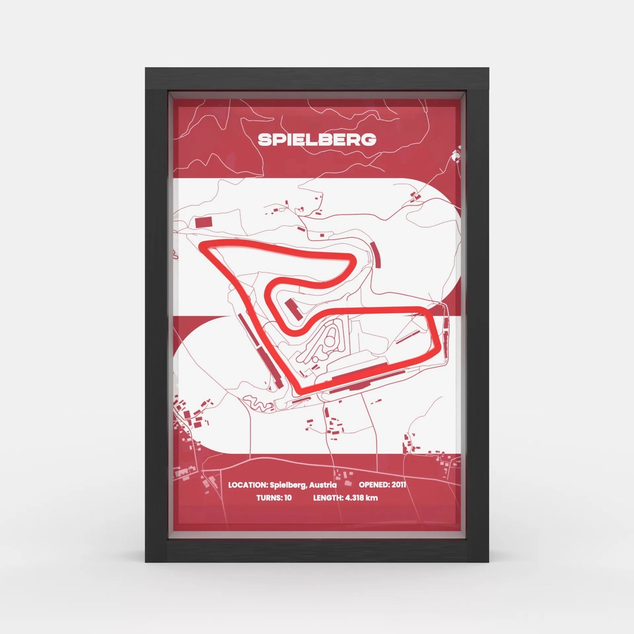 A framed minimalist map print of the Spielberg race track, featuring a red and white design with a black frame, shown against a light gray background.
Side profile Red Bull Ring track artwork showing elevation layers